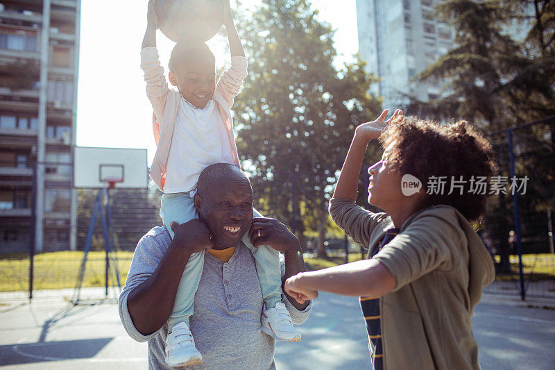 爷爷和孙子们在户外篮球场打篮球