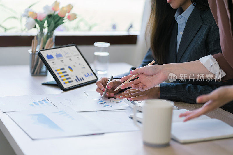 两位女性财务业务分析顾问使用数据仪表板图形、图表、指标和KPI来分析业务绩效。
