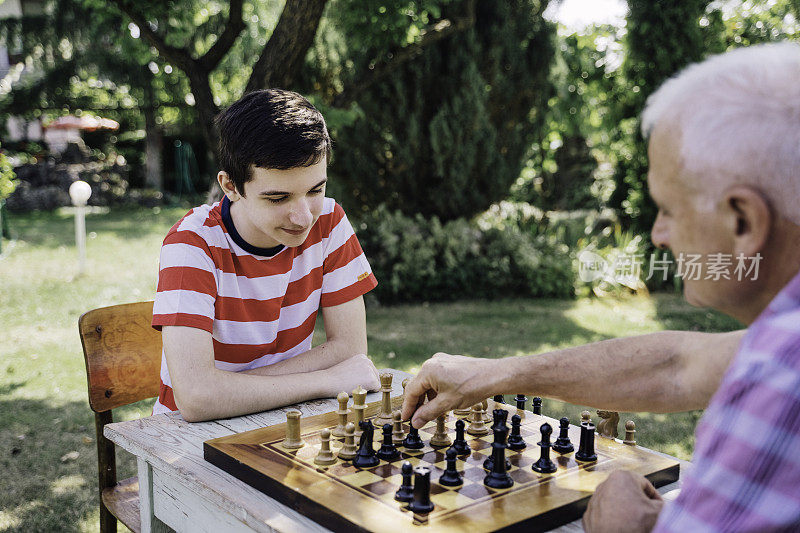 爷爷和孙子在一起下棋。