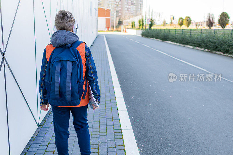 一个戴耳机的男生放学后要回家。