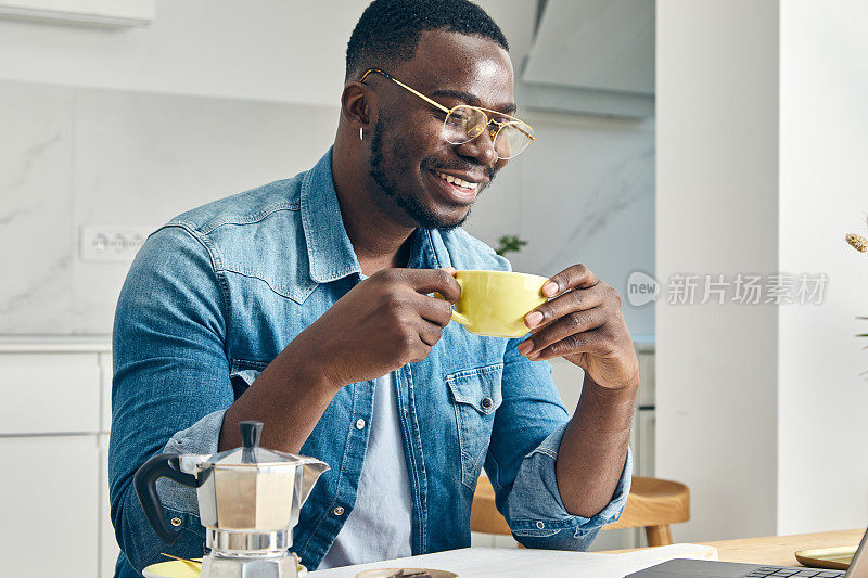 一个年轻人在家里一边喝着咖啡一边做着副业