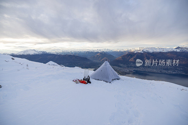 在雪地里露营，帐篷是建在一个湖、山脉之上的高峰上