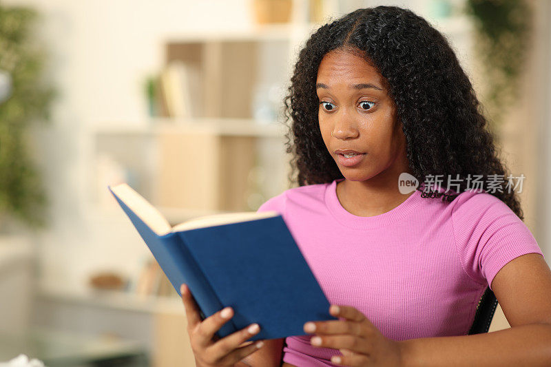 惊奇的黑人妇女在读一本纸质书