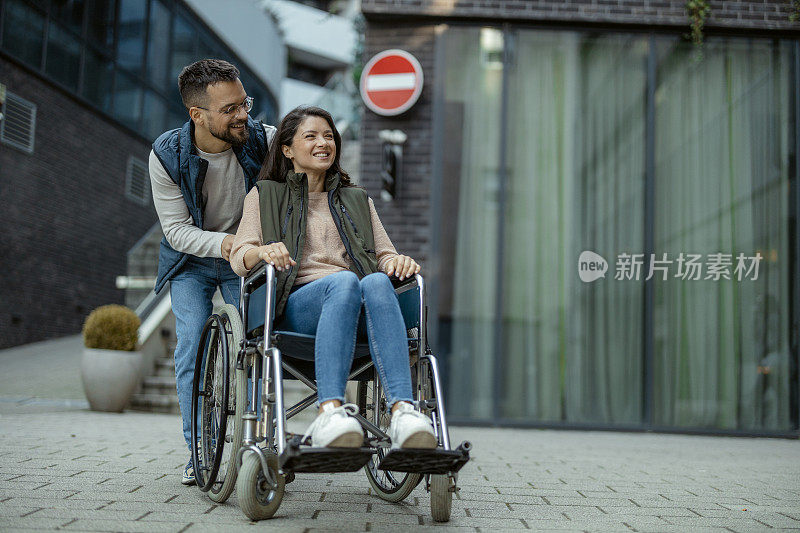 坐在轮椅上的残疾妇女和她的丈夫在市中心