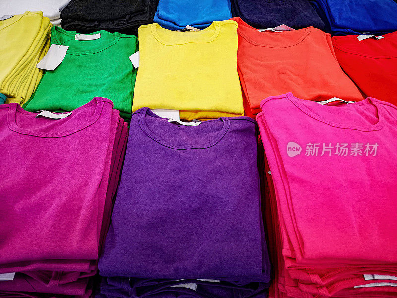 在一家高街的女装时装店，一堆堆五颜六色的t恤挂在衣架上出售。