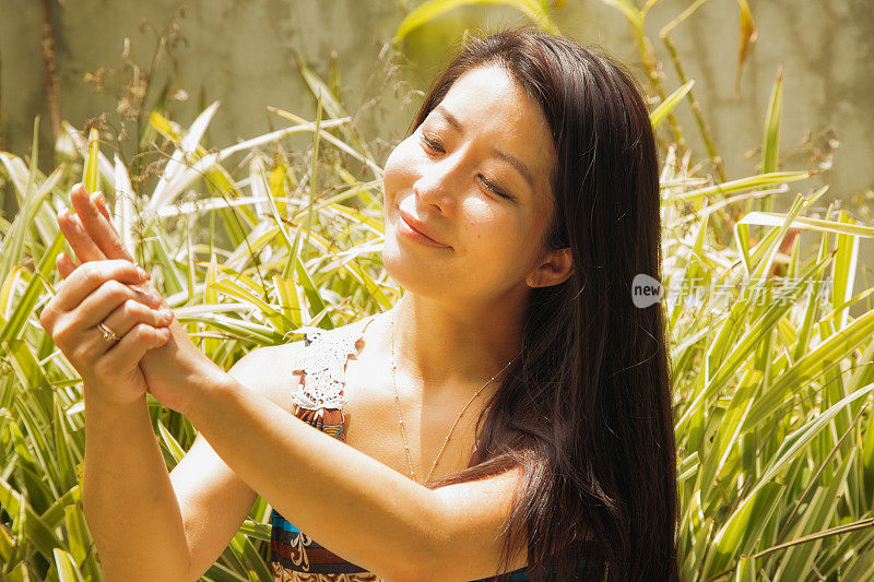 日本中年妇女在阳光明媚的一天在户外涂抹防晒霜