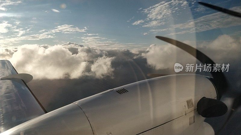 一架小飞机从云和天空中飞过