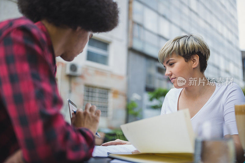 两个年轻的学生在咖啡馆一起学习