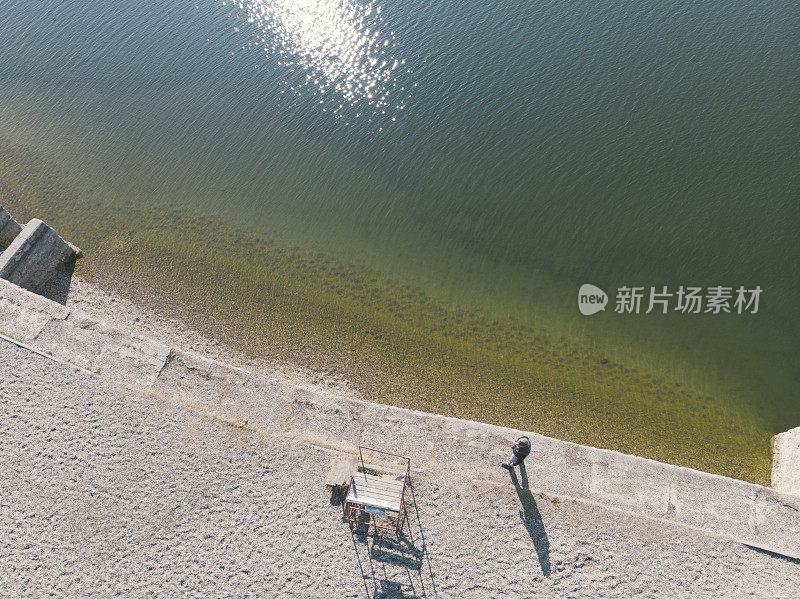 英俊的成年男子走在湖边。鸟瞰图。