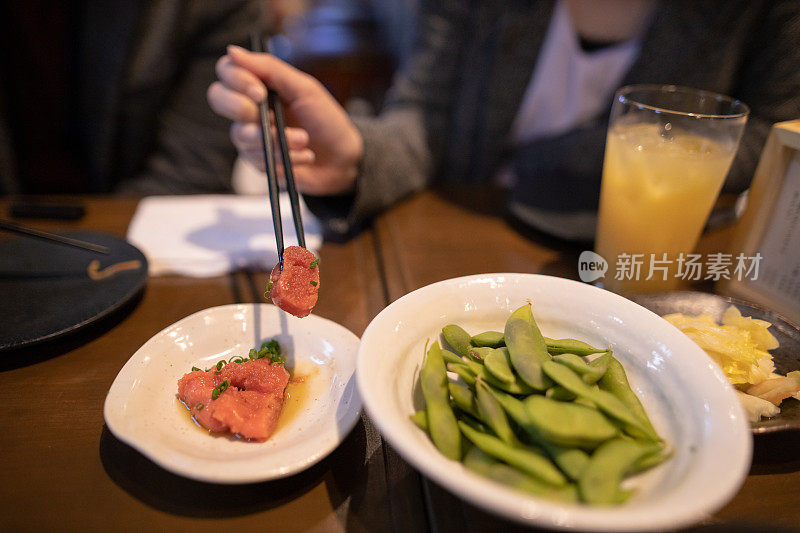 用筷子夹鳕鱼的女人