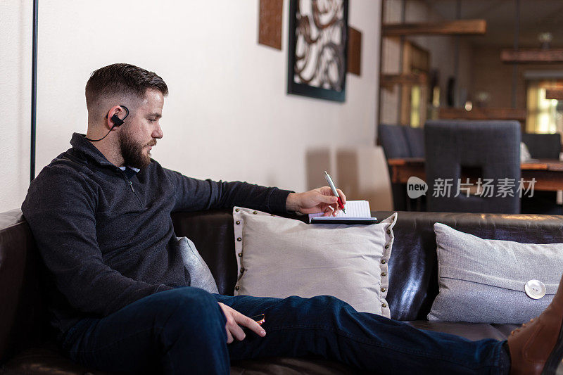 千禧一代男性在家戴耳机听音乐