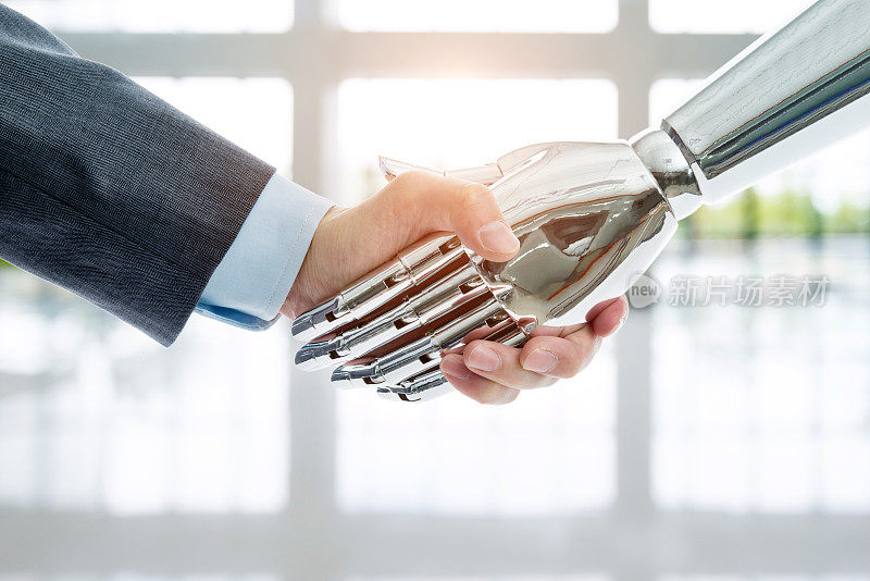 商人和机器人握手在现代办公室的背景