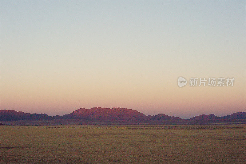 美丽的沙漠景观与粉红色的日出山