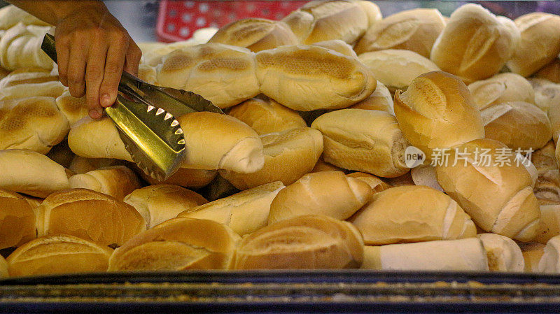 一个大的面包容器，手里拿着抹刀，抓着一个面包