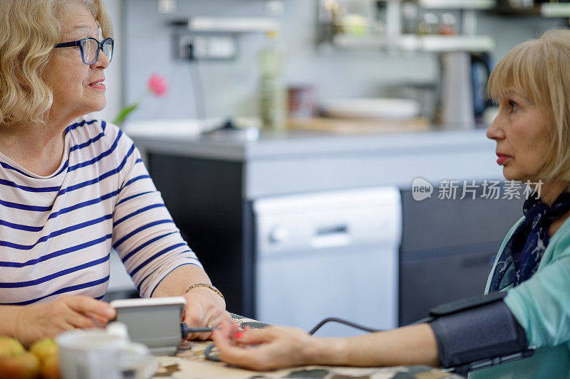 两位老年妇女在家测量血压