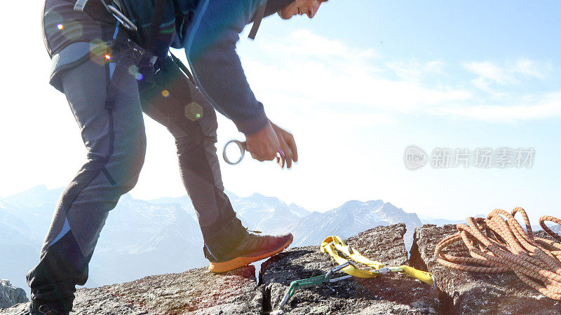 登山者在岩顶放置装备，以确保绳索安全