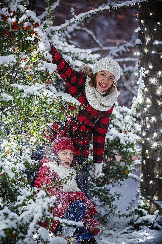 妈妈和女儿在雪中玩耍