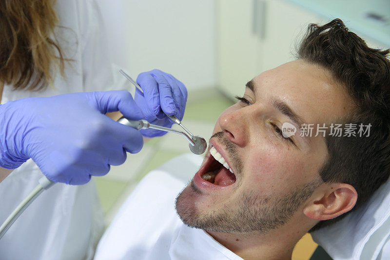 年轻人正在牙科诊所接受牙科治疗