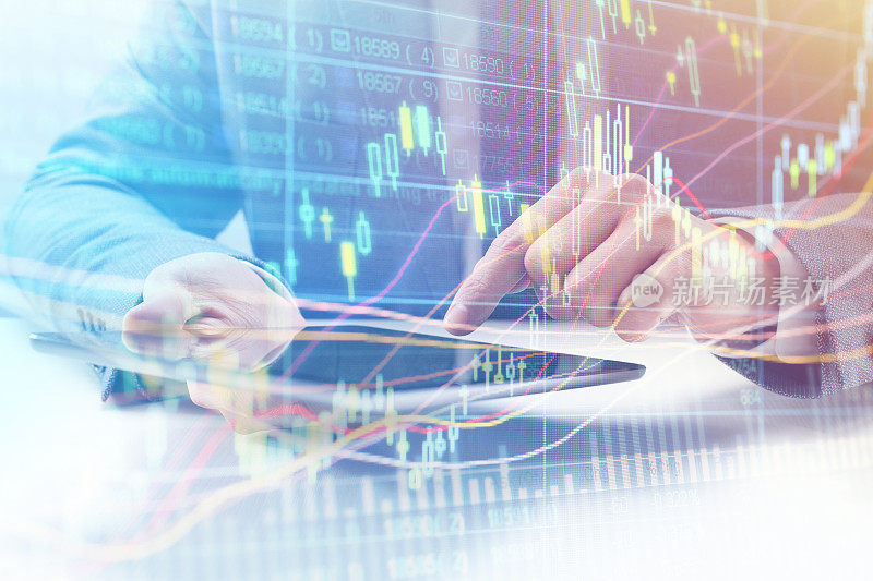 商人使用平板电脑分析金融股票市场图表和投资