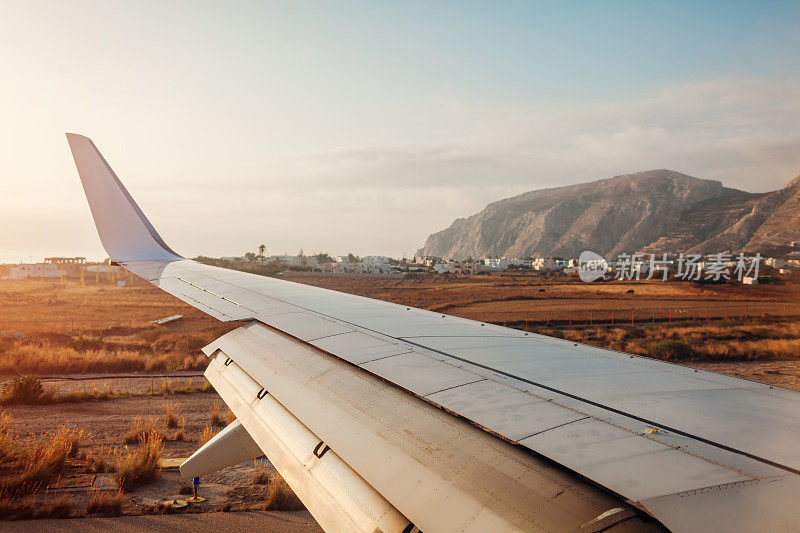 飞机在圣托里尼岛的菲拉降落。飞机机翼的视图。旅游的概念