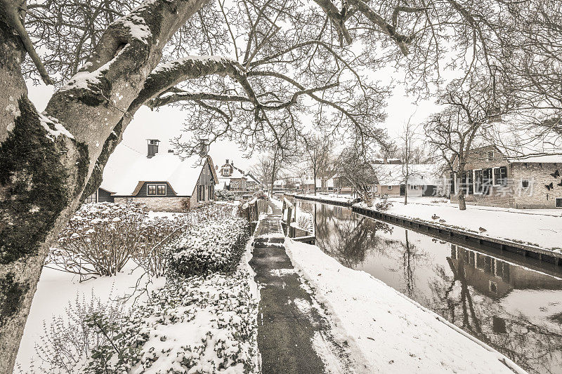 在一个寒冷但美丽而平静的冬天，Giethoorn村附近的Dwarsgracht有积雪的运河