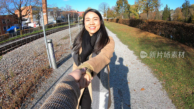 在瑞士Thun，一对浪漫的情侣手牵着手拍照