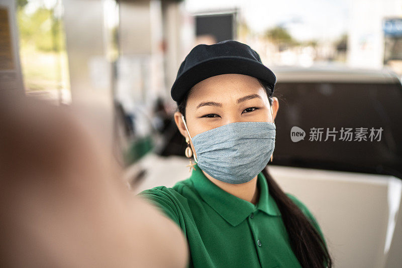 女加油站服务员在工作时戴着口罩自拍