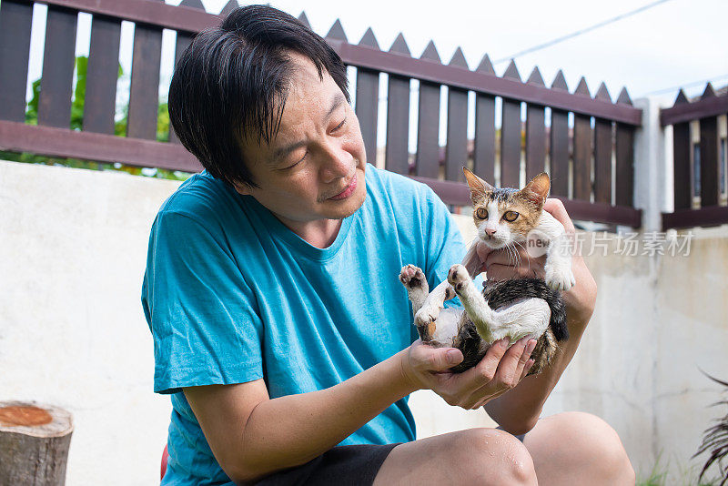 一个成年男子在欣赏和看着他美丽的小猫