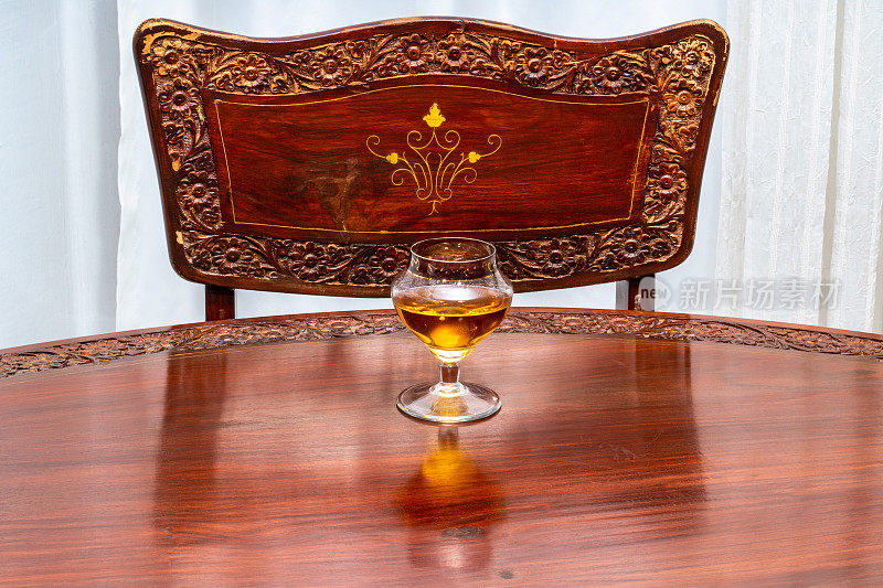 干邑白兰地和复古玻璃杯放在旧桌子上