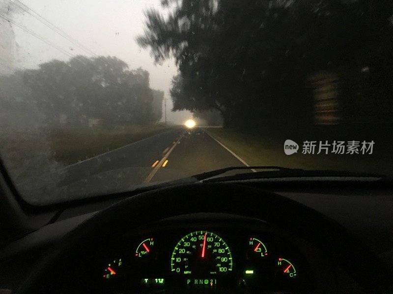 在黎明前的大雾中行驶，迎面驶来的汽车前灯发出漫射光
