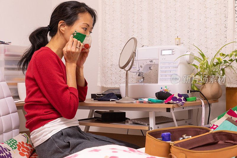 一名日本妇女在家里制作面具