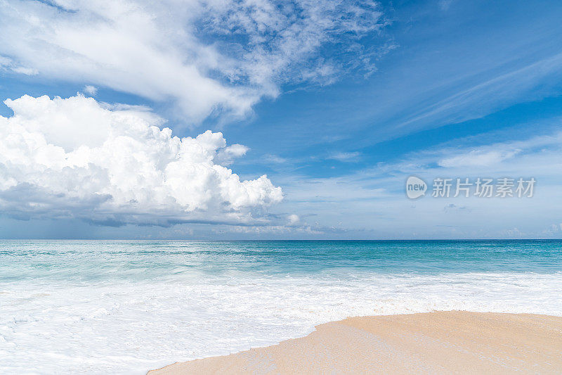 巴厘岛的海滩景象-碧绿的印度洋，白色的沙子和蓝色的天空在背景。