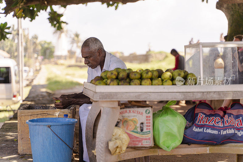 斯里兰卡加勒的街头小贩，正在清理和剥芒果