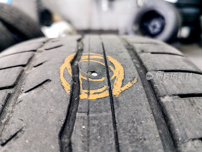 特写:在汽车修理店用钉子刺穿汽车轮胎