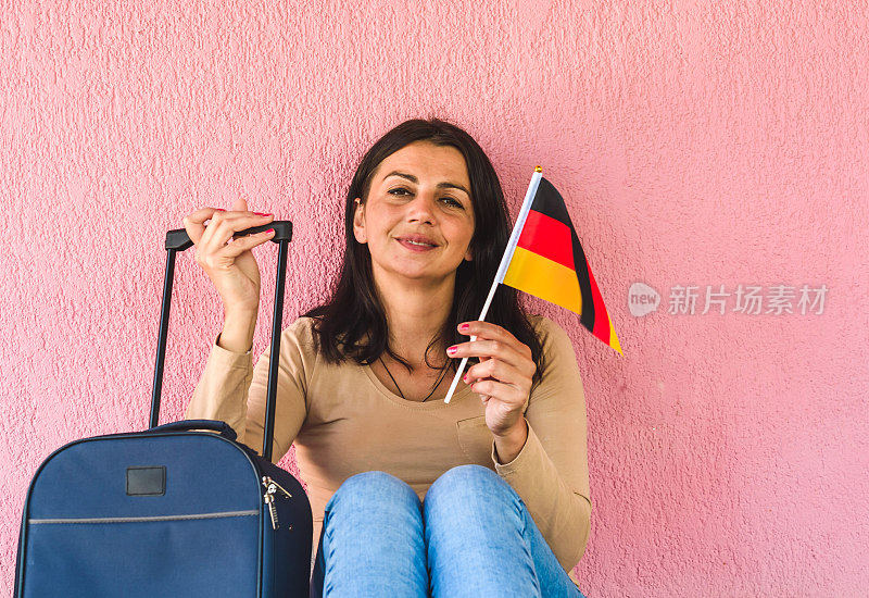 拿着旅行袋和德国国旗的女人