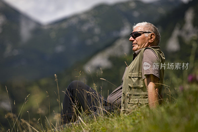 坐在草地上放松的老人徒步旅行