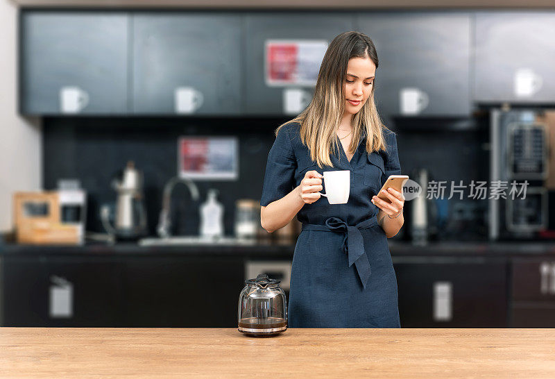 美丽的女商人在现代化的厨房里喝咖啡