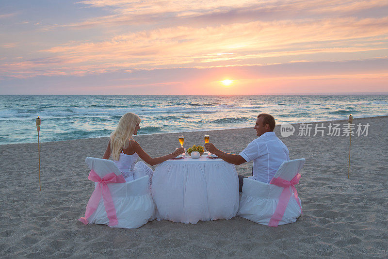 一对情侣在海滩上吃烛光浪漫晚餐