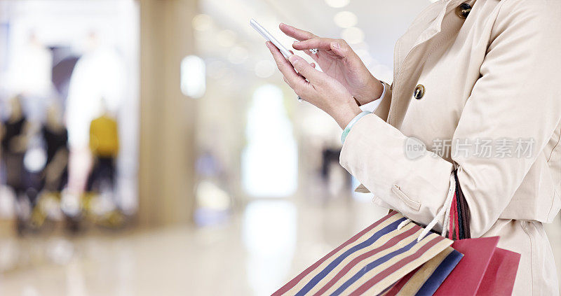 一个女人在购物时使用手机