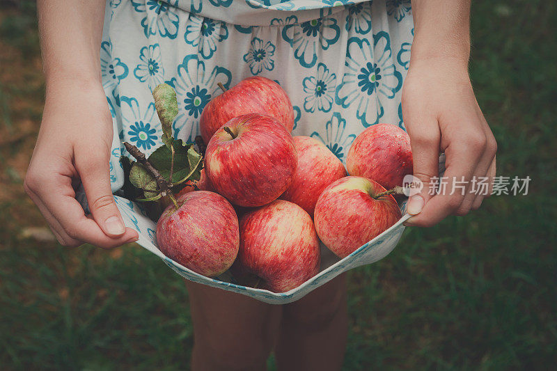 女孩在裙边拿着苹果