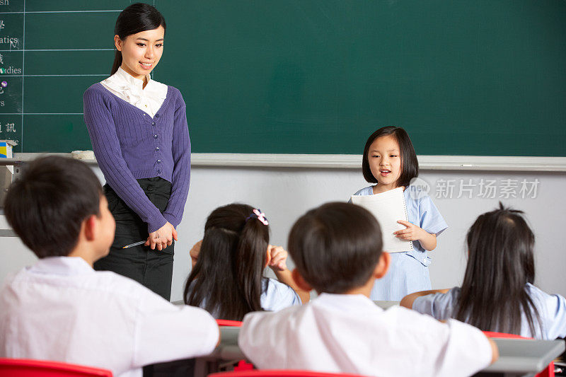 中文学校教室里，师生站在黑板旁