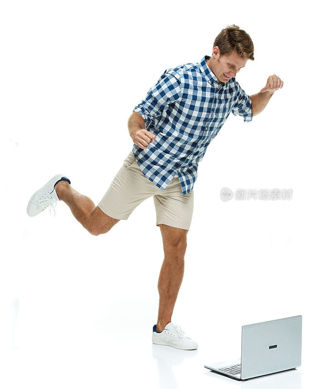 一个男人踢着笔记本电脑