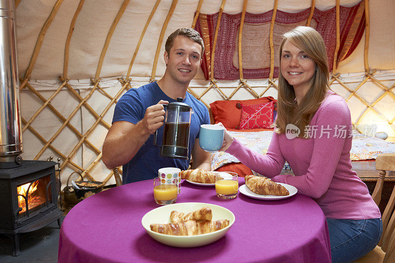 一对夫妇在传统毡房露营时享用早餐