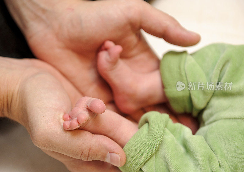 新生儿的脚，父亲的手