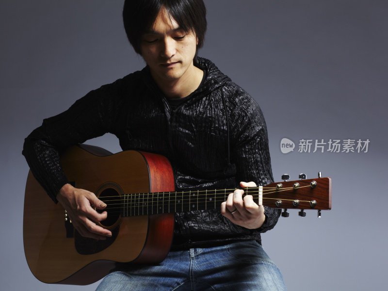 弹奏原声吉他的亚洲音乐家