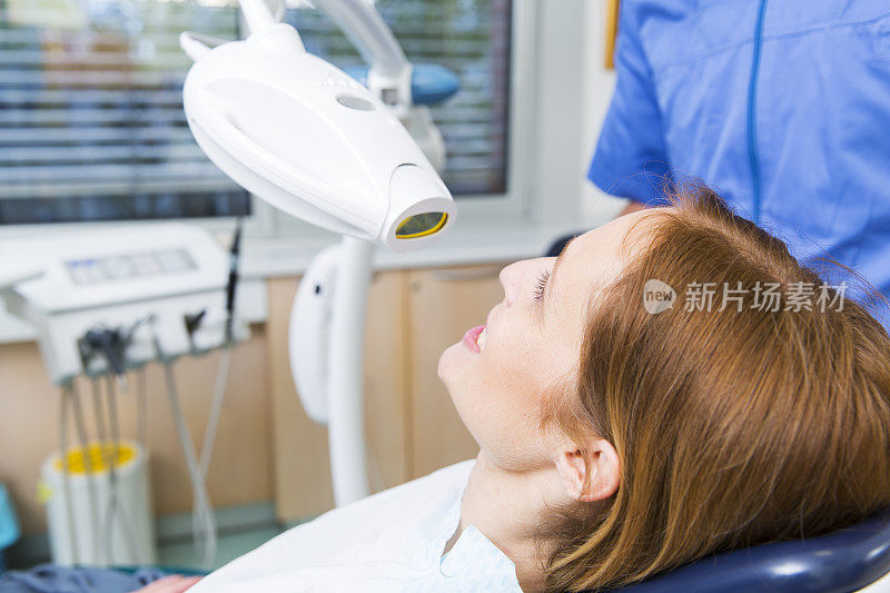 牙医正在用一种特殊的设备为病人进行牙齿漂白