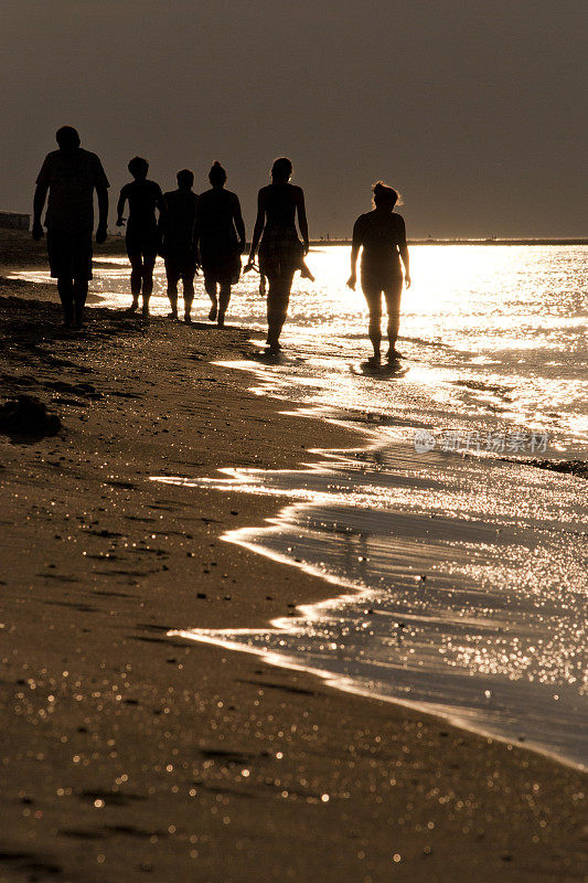 黄昏时分，6个人沿着北海海滩散步的剪影