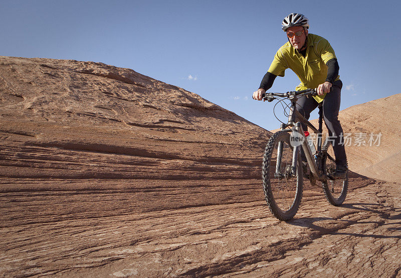在犹他州摩押的滑岩小道上的山地自行车手。