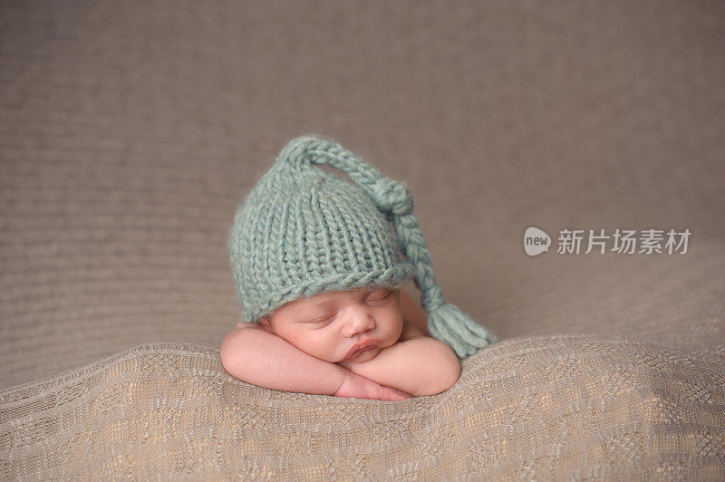 新生男孩睡在针织帽里