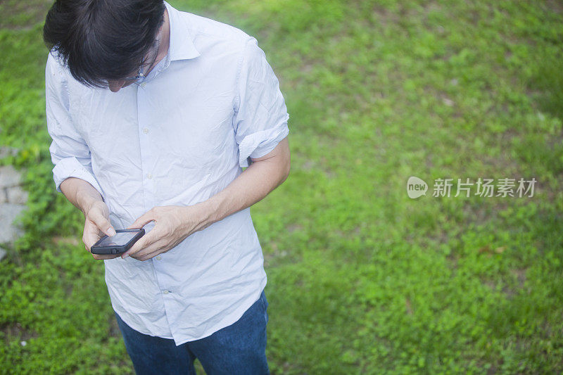 一个男人在外面用他的触摸屏手机